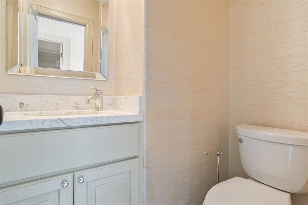 A thoughtfully placed third-level powder room offers added convenience for guests enjoying the entertainment space—complete with marble countertops and refined wall treatments for a polished finish.