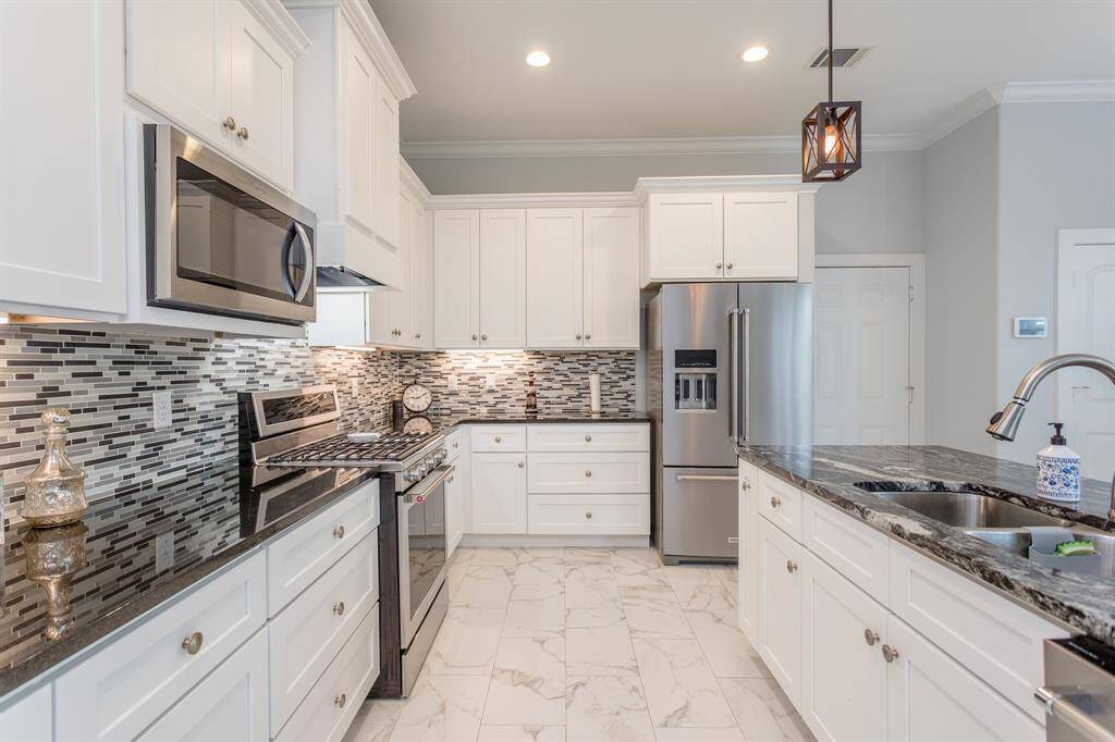 Beautiful kitchen with granite and marble countertops and floors. Soft-close cabinets and deep-set drawers. Large island that has a breakfast seating area on the other side.
