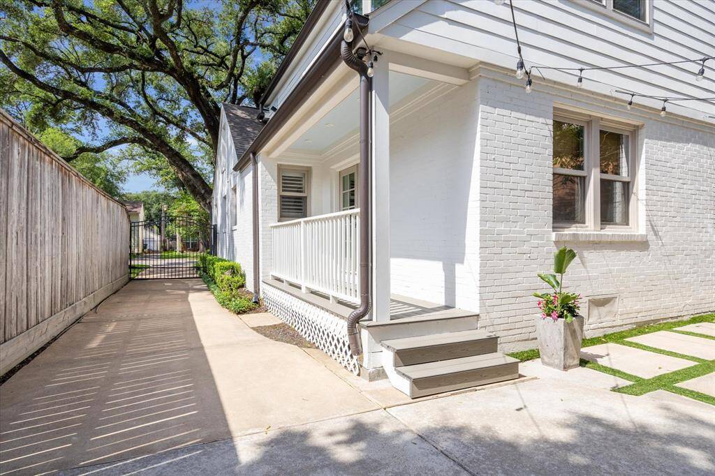 Gated driveway, a view of the mature oak out front and the covered patio.