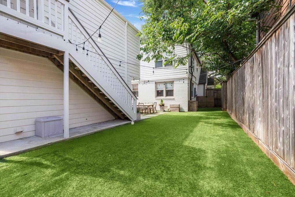 A view of the great turfed yard and stairs to the garage aparment.