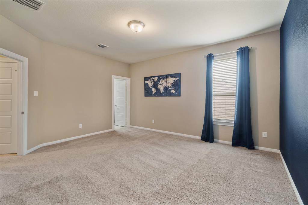 Spacious game room featuring a built-in entertainment center with floating shelves and a built-in wet bar and kitchenette. Large windows and a glass door offer natural light and access to the outdoor balcony with retractable screens. Perfect for entertaining and relaxation. *TV excluded.