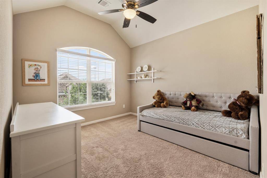 Bright and cozy bedroom with vaulted ceiling, featuring a large window for natural light. Ensuite bath and large walk-in closet.