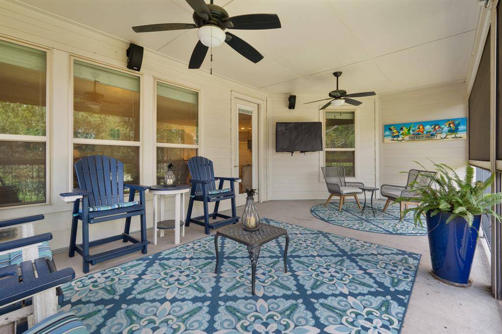 This inviting, spacious motorized screened porch features a cozy setting, ceiling fans, and a wall-mounted *TV, and retractable screens perfect for relaxing and entertaining. Easy access to the game room and kitchenette area. Added exterior passenger door with in-frame blinds to balcony. Added Bose outdoor environmental speakers. *TV excluded.