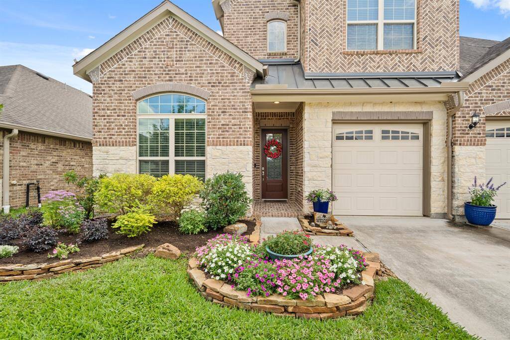 Charming brick and stone exterior with a welcoming front entrance. Features a well-maintained garden, colorful flowers, and a 3-car garage. Perfect for those seeking curb appeal and a cozy atmosphere. Added stone retention wall, rerouted irrigation and plantings.