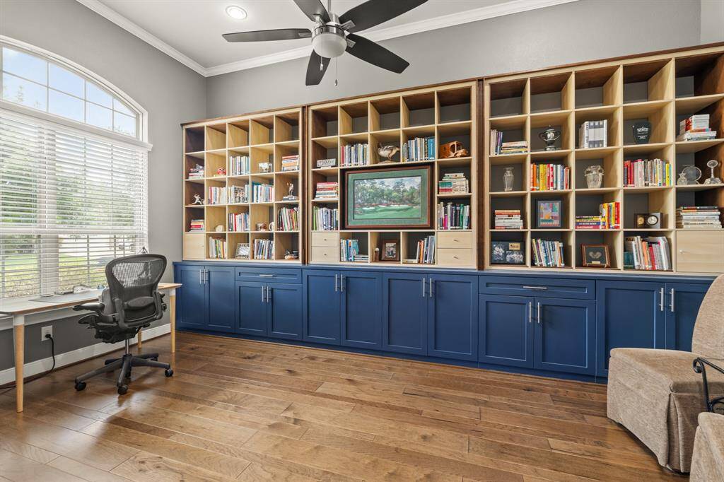 This home office features a large window for natural light, built-in shelving with ample storage, elegant Benjamin Moore paint and engineered flooring. Perfect for a productive work environment.