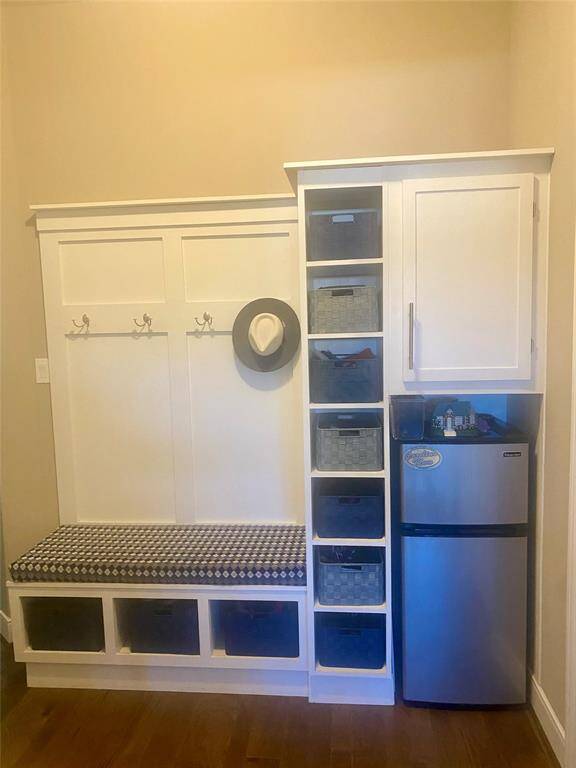 Added custom bench, coat hanging, shelving, storage cabinet and Mini-Fridge near garage passenger door and utility room.