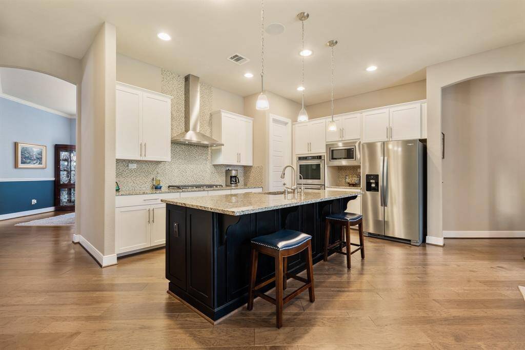 Bright and elegant dining room with large windows, chair rail and crown molding, a stylish light fixture, elegant Benjamin Moore paint, engineered flooring, creating a welcoming space for gatherings.