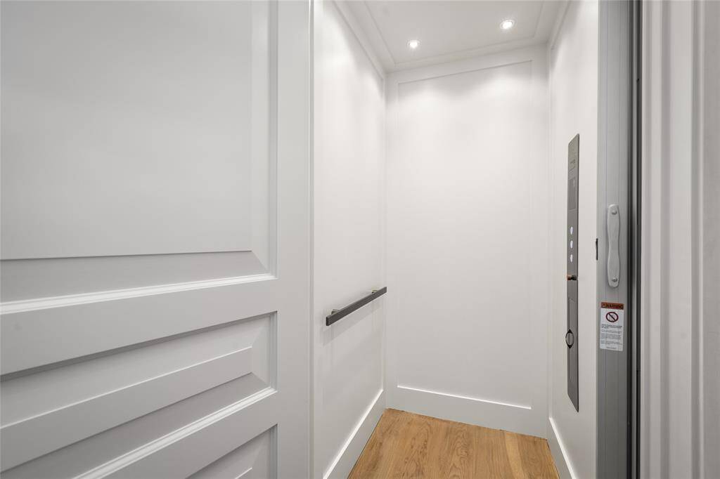 Elegantly paneled elevator with white oak flooring ready for the new homeowner to personalize