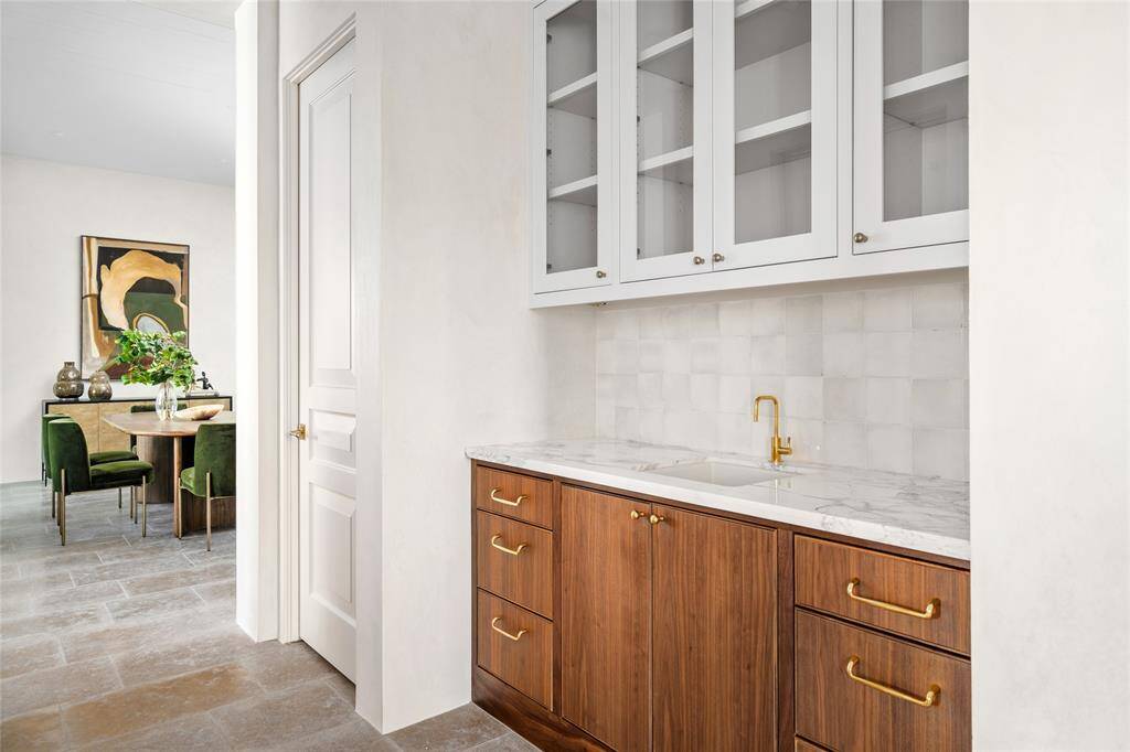 Formal Wet Bar with marble counter and walnut sink base, Newport Brass fixture, glazed glass front upper cabinets and filtered water