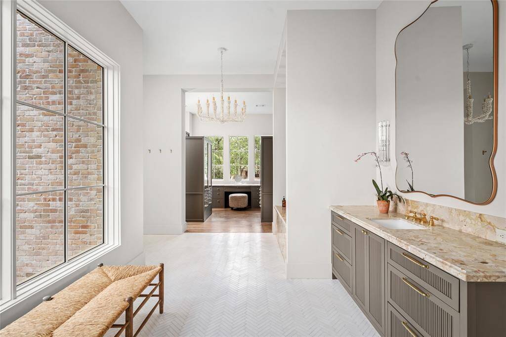 North Bathroom with incredible bench made glazed finished vanity with gorgeous marble top, Perrin and Rowe unlacquered brass fixtures, LED lighting, a pair of Murano wall sconces and a delicate and select seashell 10-light chandelier