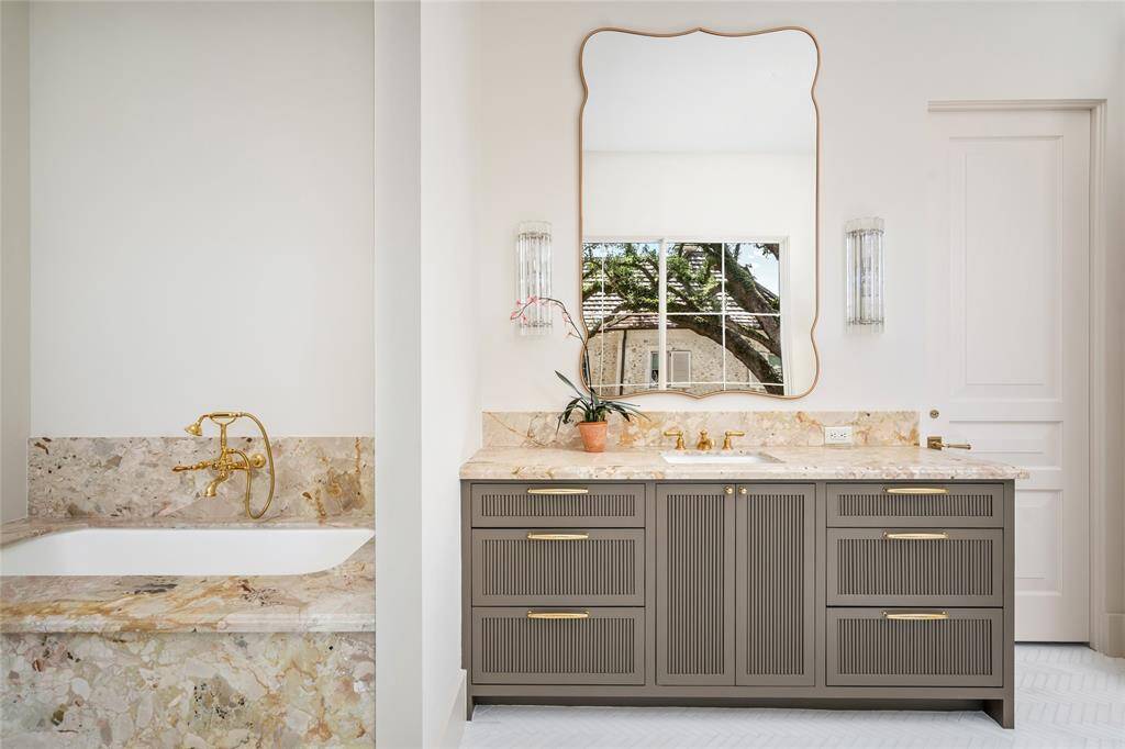 Perrin & Rowe unlacquered brass shower fixture in the spacious glass enclosed primary shower