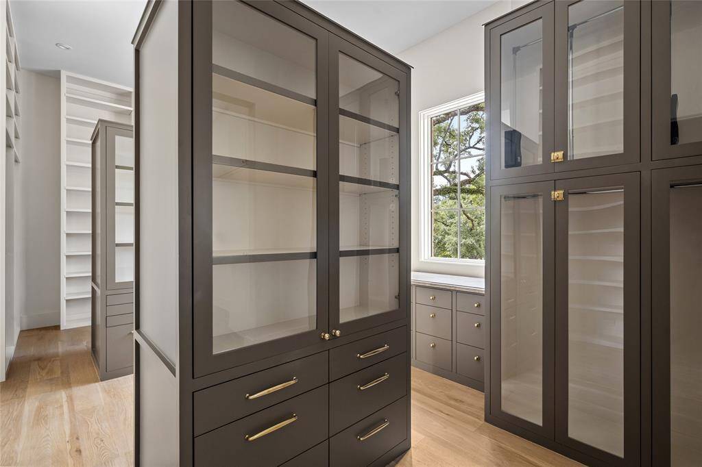 Primary Bathroom (South) modern design honed limestone flooring with glass enclosed shower having marble walls, vanity counter and Perrin and Rowe fixtures, a pair of Murano wall sconces, LED lighting, with a private w/c