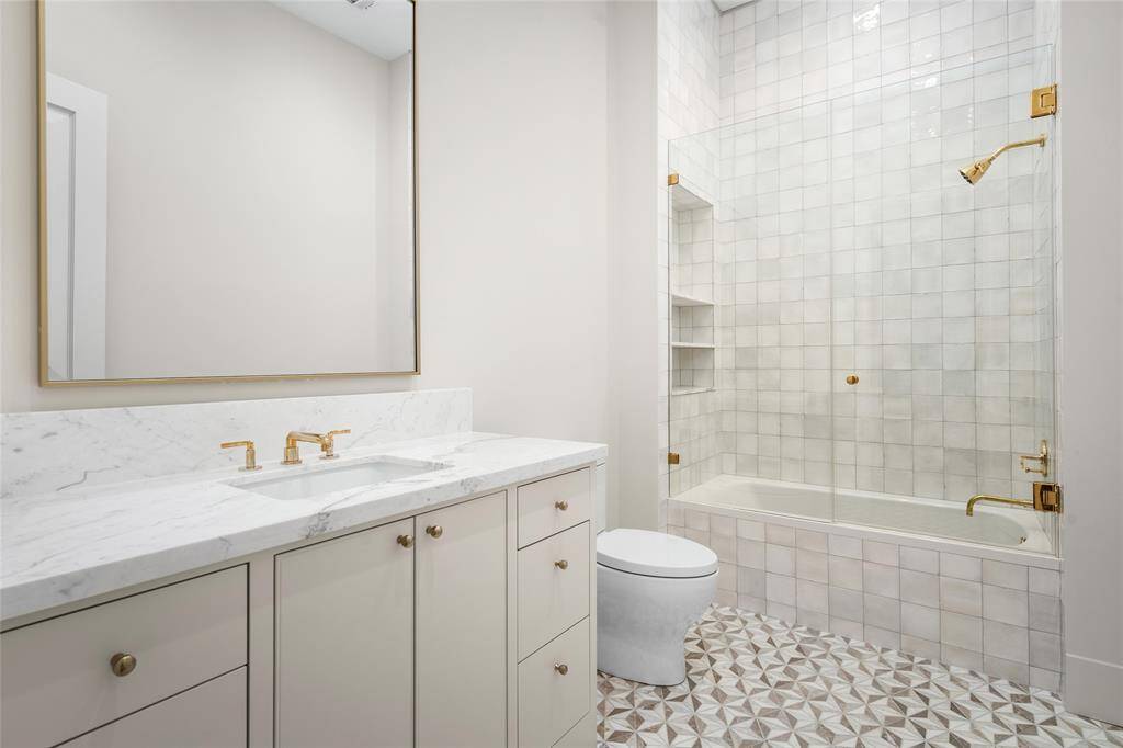 En-suite bathroom 3 with mosaic marble tile flooring, glass enclosed tub/shower, marble top vanity and Newport Brass fixtures