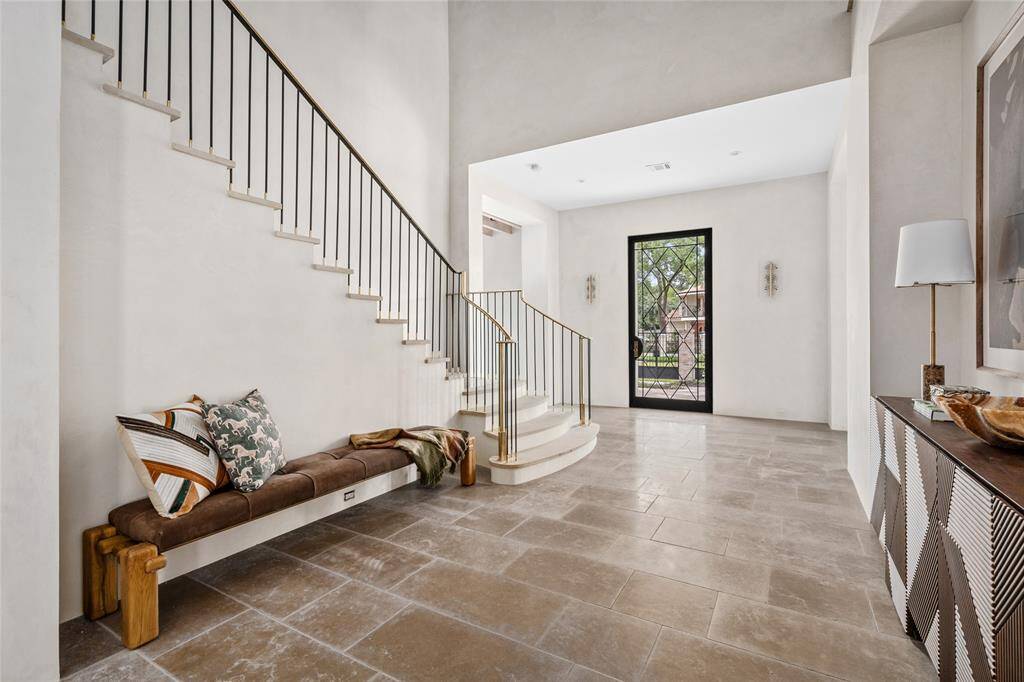 The front entry flanked by a pair of Murano sconces, European limestone flooring and soaring artisanal plaster walls of 26 feet in height