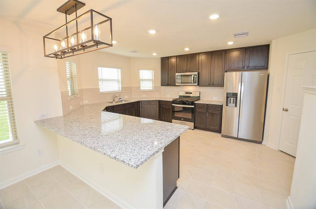 Discover the charm of this upgraded kitchen, featuring sleek countertops and modern stainless steel appliances.