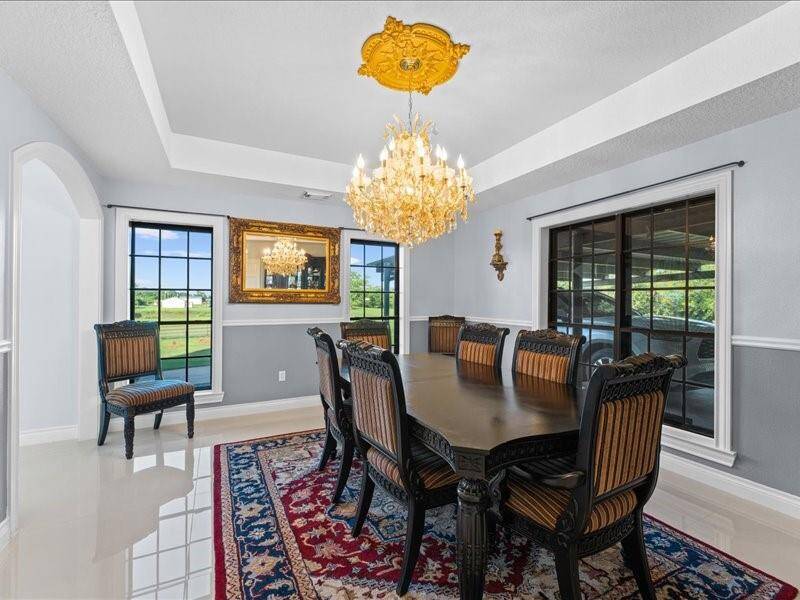 Elegant dining room with a luxurious chandelier, and large windows for natural light,  creating a sophisticated atmosphere.