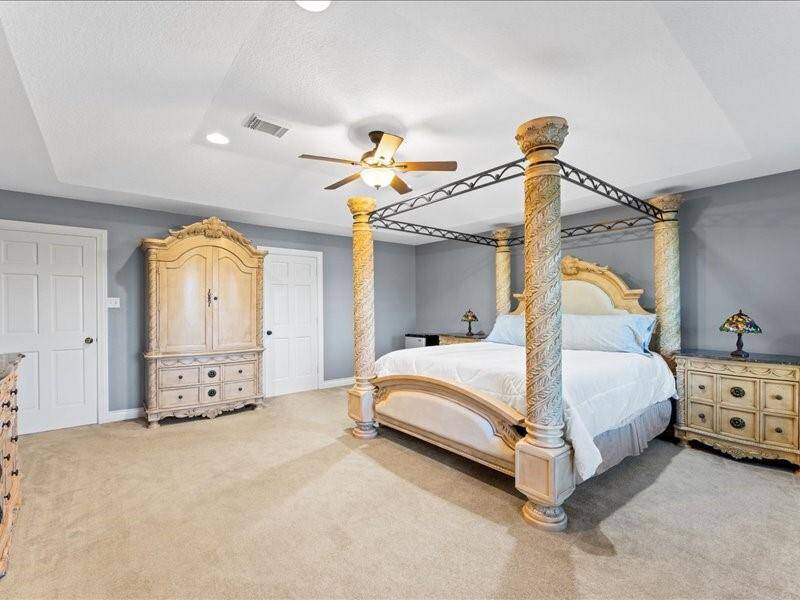 Spacious bedroom with neutral carpet.