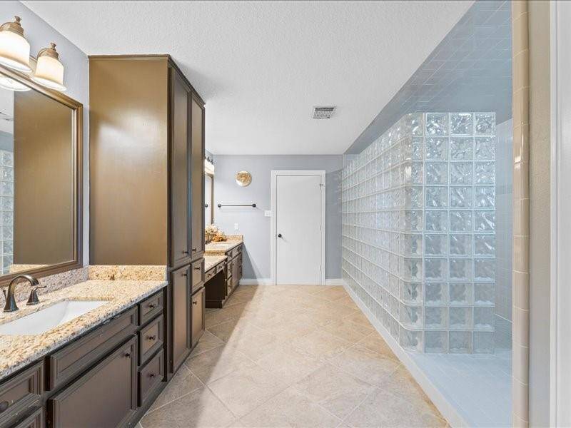 Spacious bathroom with dual sinks, granite countertops, and ample storage.
