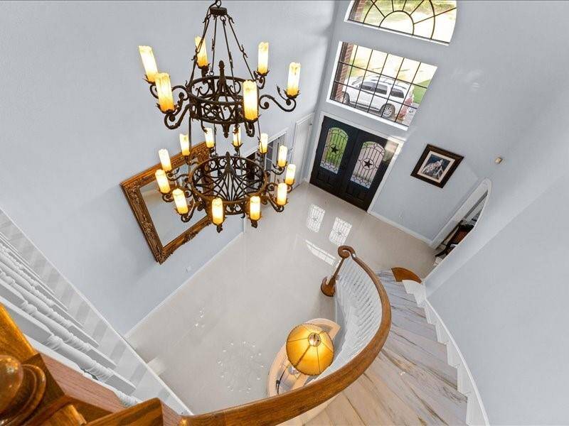 The grand foyer with the sweeping staircase, and the elegant chandelier, create and inviting entrance.