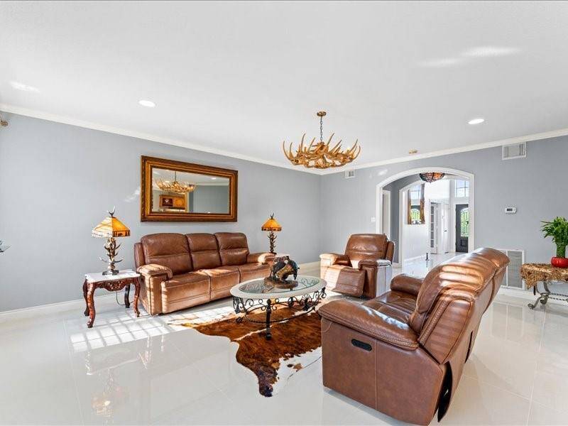 Bright and spacious living room with sleek white tile flooring and neutral gray walls.