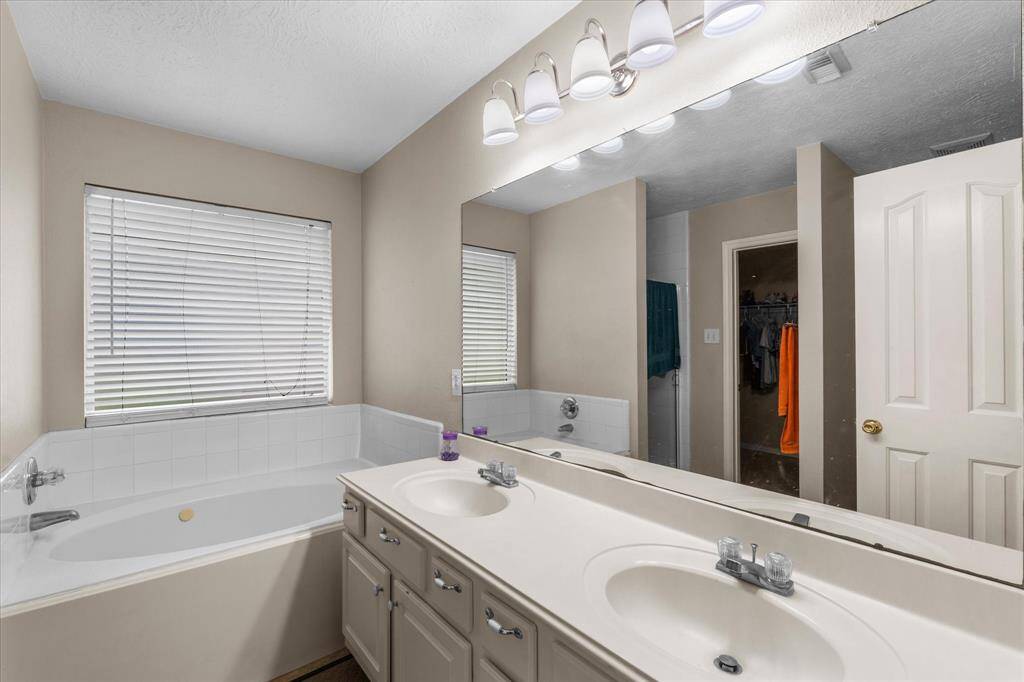 Primary Suite with a tub and Him & Her Sinks.