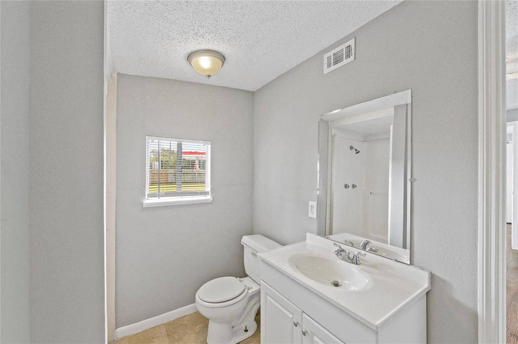 The attached primary bath is equipped with a standing shower.