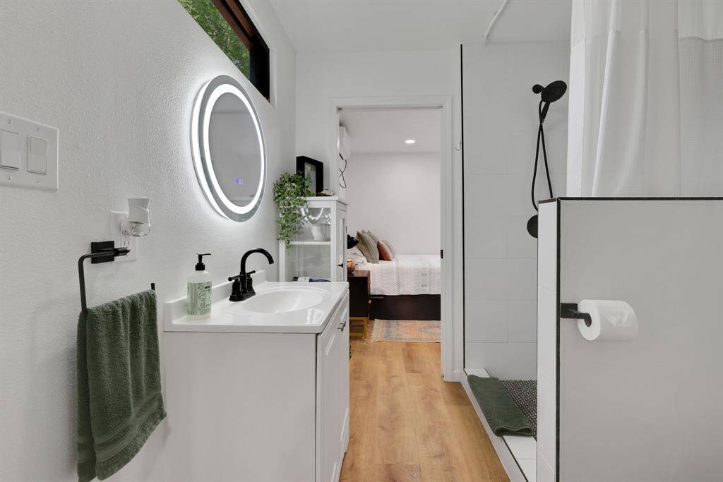 The full bathroom has a walk in shower and vanity with storage