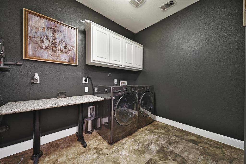 Laundry room includes cabinets and space for a refrigerator or freezer.