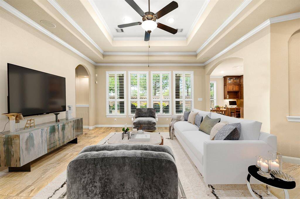 This living room is more like a GREAT room featuring a stunning fireplace with mantel detailing, custom paint, soaring high ceiling, recessed lighting, dark stained ceiling fan, and an amazing wall of windows providing a lovely view of your backyard to keep an eye out on the kids or pets playing. *Virtually Staged