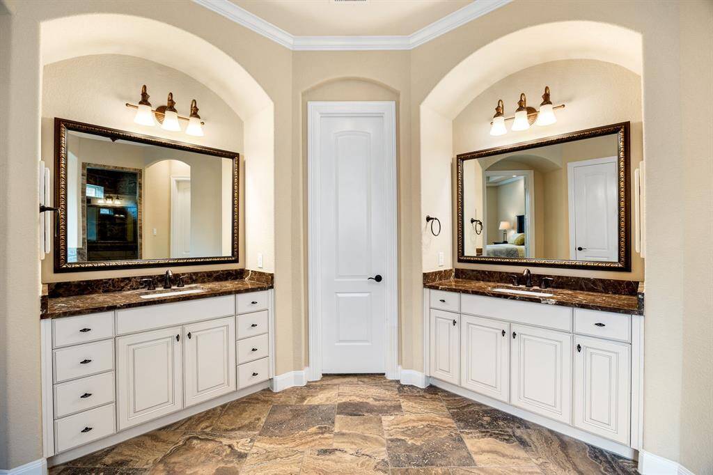 Experience spa-like luxury in this beautifully designed primary ensuite, complete with dual arched vanities, beautiful countertops, and ample storage for a truly indulgent retreat.