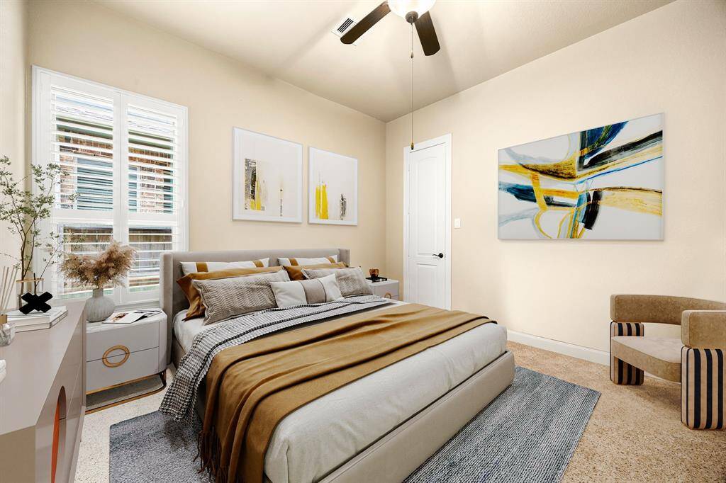 Secondary bedroom features plush carpet, custom paint, dark stained ceiling fan with lighting and a large window with privacy blinds. *Virtually Staged