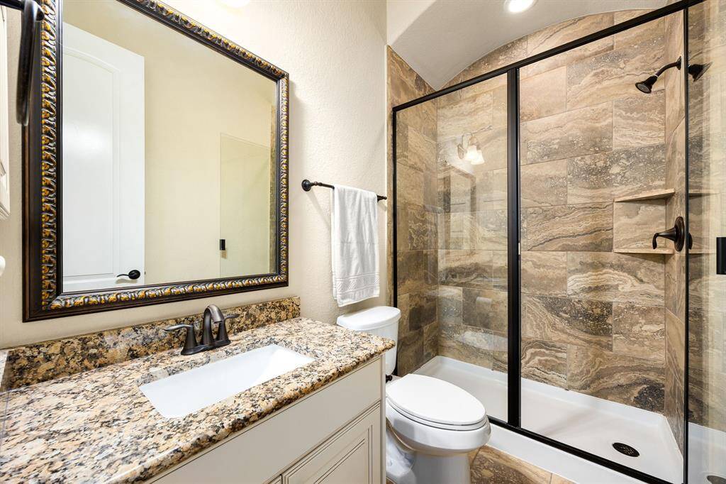 Secondary bathroom features light countertops and cabinets, custom paint, shower/tub combo with tile surround, large mirror, tile floors, sleek fixtures and modern finishes, plenty of space to accommodate any visiting family or guests.