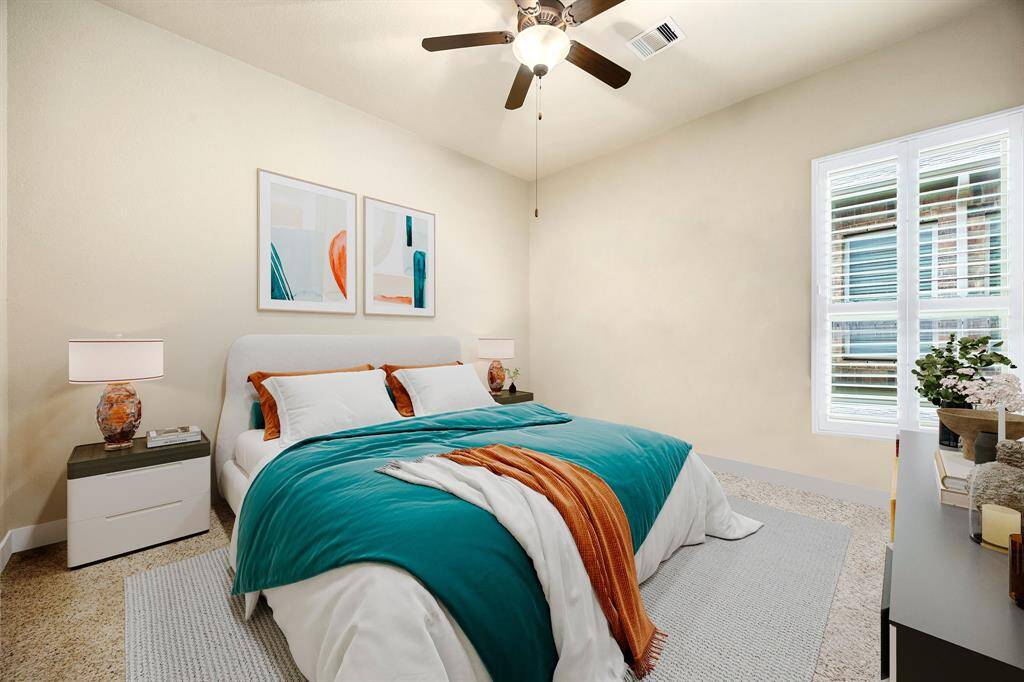 Secondary bedroom great for use as an in-law suite or guest suite features high ceilings, lovely modern ceiling fan, custom paint, plush carpet, space for seating area, direct access to the secondary bathroom and large window with shutters. *Virtually Staged