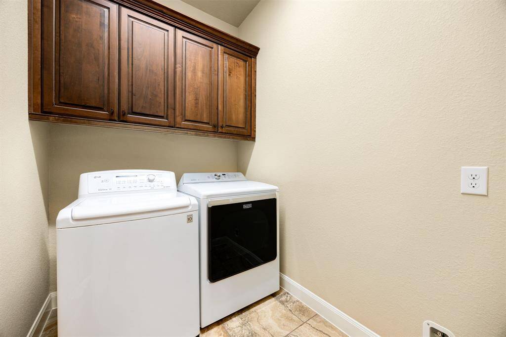 Conveniently positioned near the front of the home, this laundry room offers generous cabinet storage and a practical layout to streamline everyday chores.