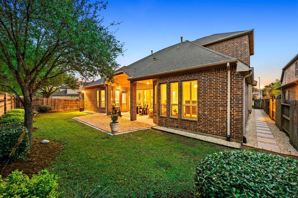 A welcoming backyard retreat with plenty of room to relax, grill, or gather under the warm glow of porch lighting.