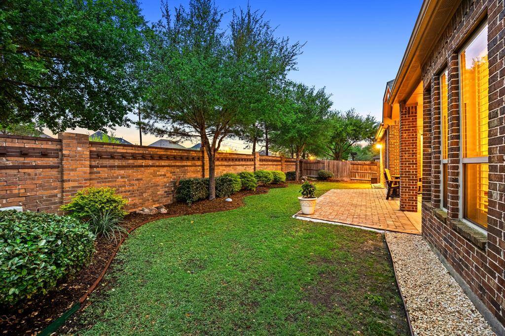 This well-maintained yard offers both privacy and charm, framed by the home’s striking brickwork and thoughtful landscaping.