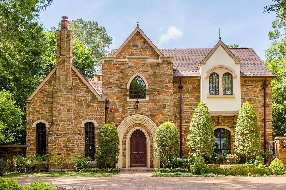 European inspired exterior featuring real stone, stucco, custom designed and crafted front door. Extra parking in front, side entry through secure driveway gate to 3 car garage.