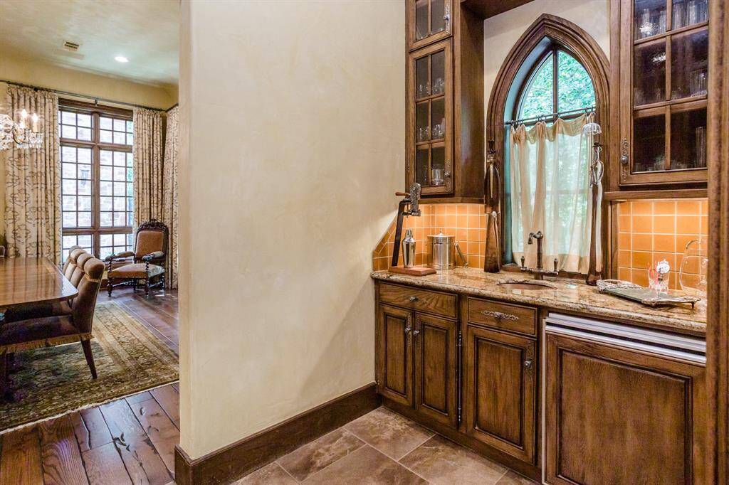 Butler pantry between dining and kitchen. Sink, refrigerator, marble counter, upper & lower cabinets for storage.