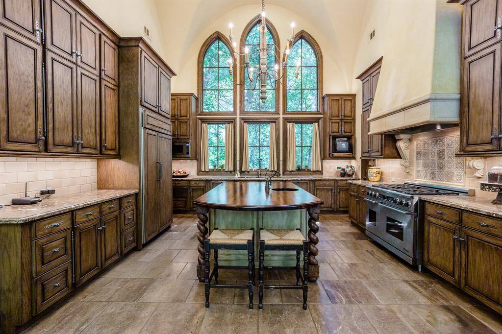 Custom kitchen featuring Swedish imported island, white oak cabinetry, pillowed marble floors, marble countertops, two dishwashers, 6 burner, double oven, Dacor range.  Three huge designer windows overlooking secluded private side yard with lush trees. Walk-in pantry.