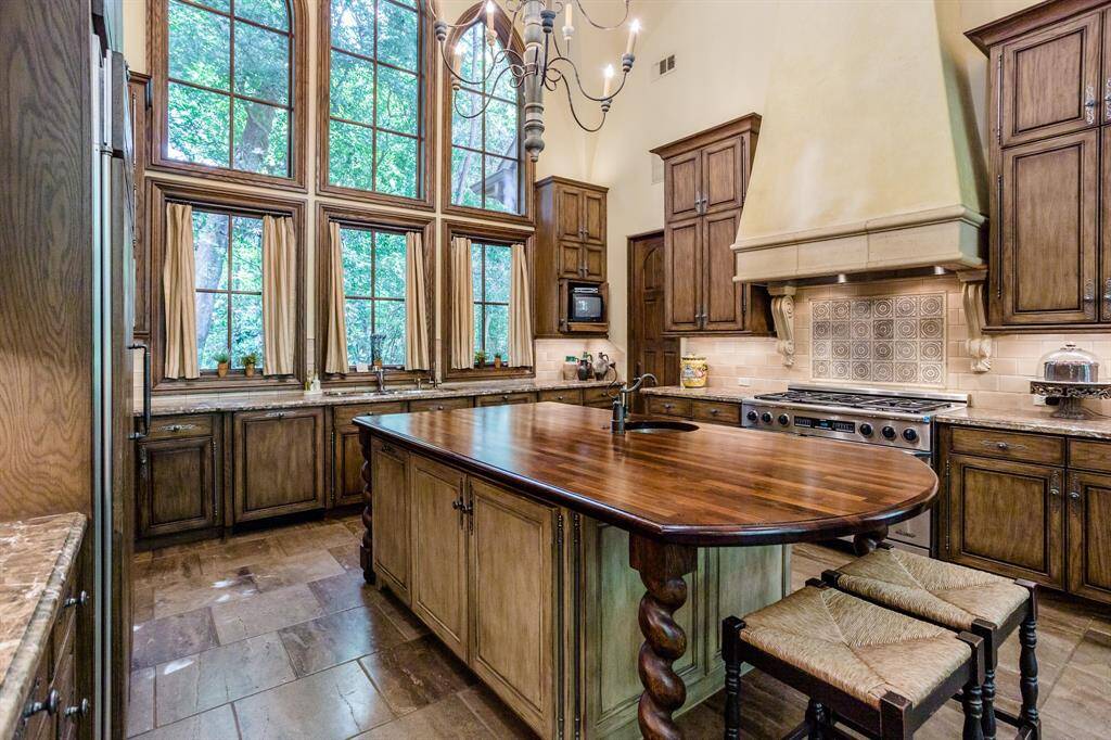 Custom kitchen featuring Swedish imported island, white oak cabinetry, pillowed marble floors, marble countertops, two dishwashers, 6 burner, double oven, Dacor range.  Three huge designer windows overlooking secluded private side yard with lush trees. Walk-in pantry.