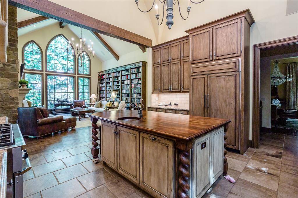 Custom kitchen featuring Swedish imported island, white oak cabinetry, pillowed marble floors, marble countertops, two dishwashers, 6 burner, double oven, Dacor range.  Three huge designer windows overlooking secluded private side yard with lush trees. Walk-in pantry. Butler pantry on right leading to dining room.