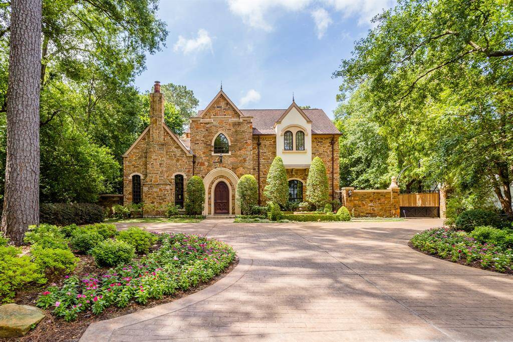 European inspired exterior featuring real stone, stucco, custom designed and crafted front door. Extra parking in front, side entry through secure driveway gate to 3 car garage.