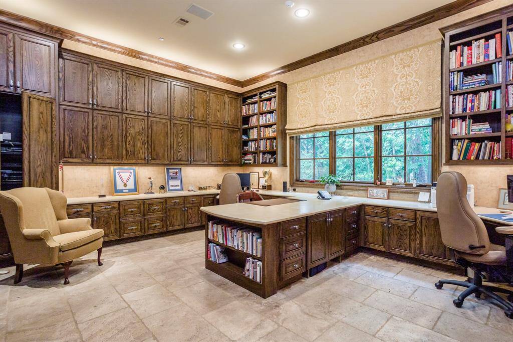 Huge home workspace features two computer work stations and one sewing/crafting station.  This room is one of the busiest rooms in the home. It also serves as a drop zone for family coming in from the garage.  Sliding hardwood doors separate it from the main hallway for the times privacy is desired.  Tumbled travertine flooring, marble countertop surfaces.  Three huge windows brings in the natural light.
