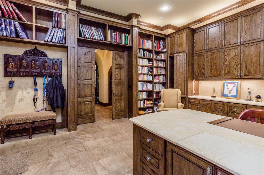Huge home workspace features two computer work stations and one sewing/crafting station.  This room is one of the busiest rooms in the home. It also serves as a drop zone for family coming in from the garage.  Sliding hardwood doors separate it from the main hallway for the times privacy is desired.  Tumbled travertine flooring, marble countertop surfaces.  Three huge windows brings in the natural light.