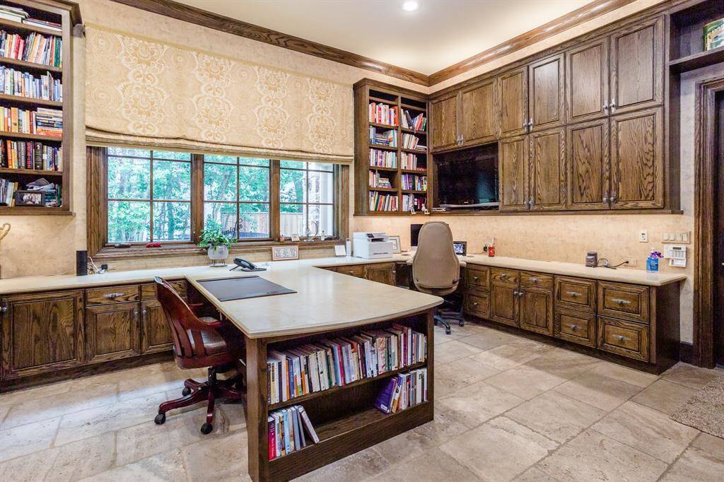 Huge home workspace features two computer work stations and one sewing/crafting station.  This room is one of the busiest rooms in the home. It also serves as a drop zone for family coming in from the garage.  Sliding hardwood doors separate it from the main hallway for the times privacy is desired.  Tumbled travertine flooring, marble countertop surfaces.  Three huge windows brings in the natural light.