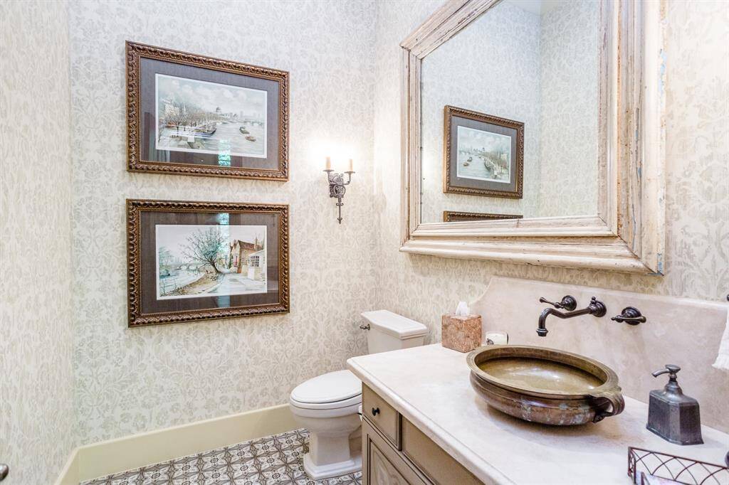 Powder room featuring European hand-painted tiles, vanity, marble top with bowl sink and wall fixtures.