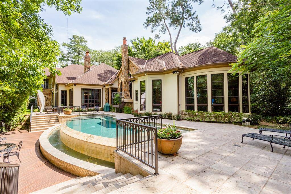 Negative edge pool with custom designed inset tiles to complement the design of the home.  Real stone and stucco exterior.  Private setting.