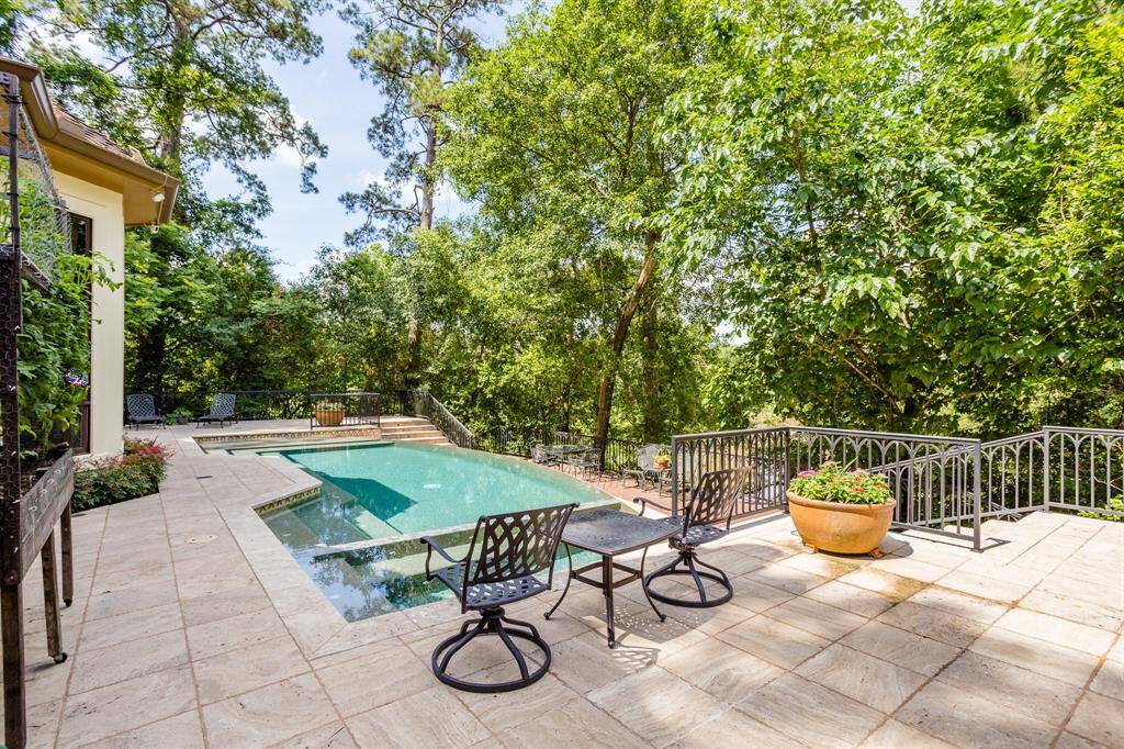 Serene, private setting among the trees. Negative edge pool with falls down to lower level deck. Plenty of space for family and entertaining.