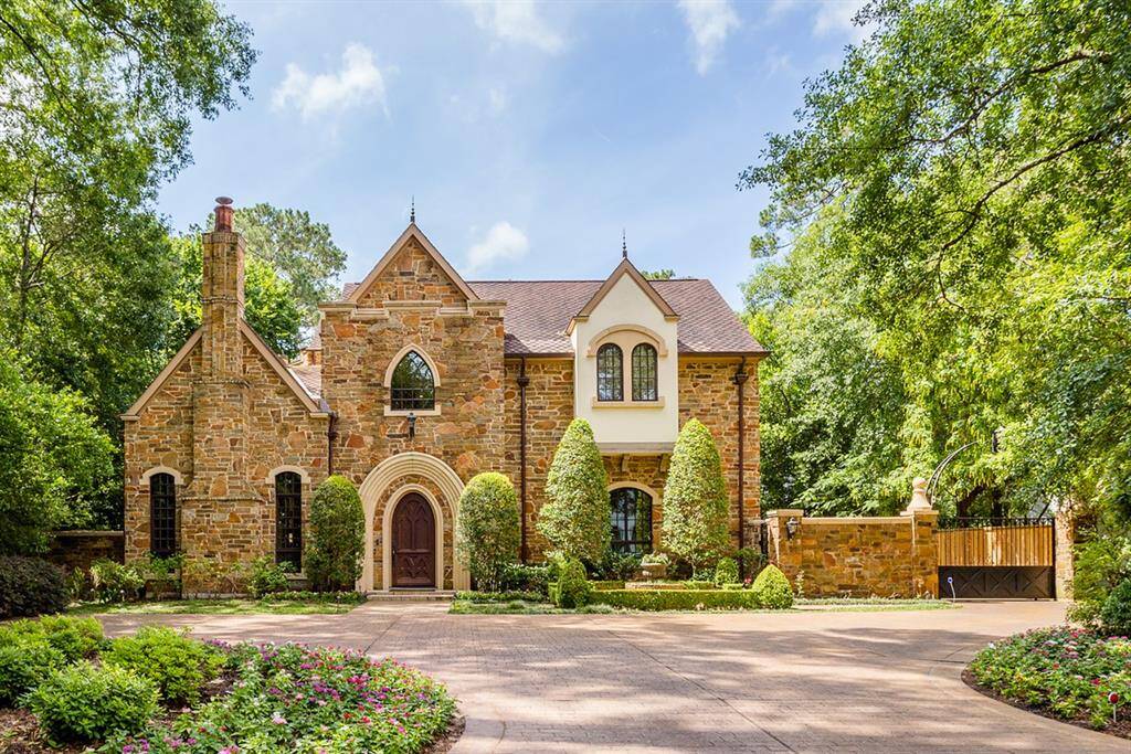 European inspired exterior featuring real stone, stucco, custom designed and crafted front door. Extra parking in front, side entry through secure driveway gate to 3 car garage.