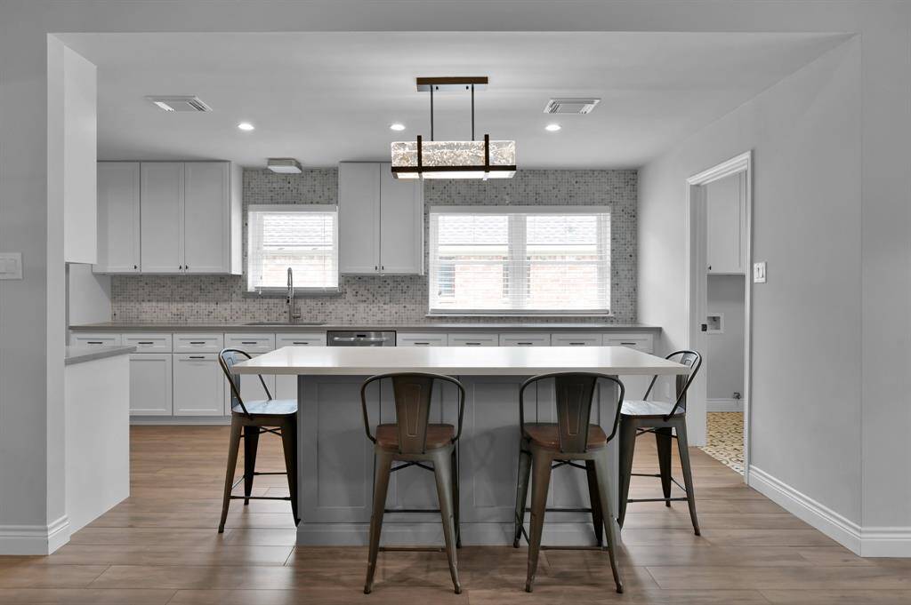 Oversized island with breakfast bar is great for meal prepping and casual dining.